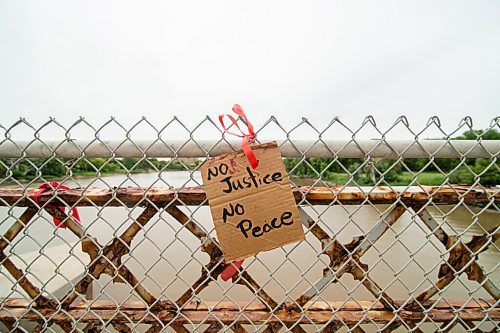 Mike Sudoma / Winnipeg Free Press
A piece of cardboard with the words No Justice No Peace hangs on the fence along the Louise Bridge Wednesday evening
September 2, 2020