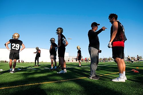 Daniel Crump / Winnipeg Free Press. University of Manitoba Bisons football team coach Brian Dobie (second from right) speaks with a player during practice at the university. September 3, 2020.