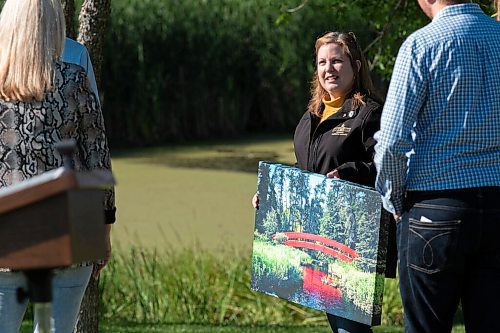 JESSE BOILY  / WINNIPEG FREE PRESS
Conservation and Climate Minister Sarah Guillemard holds a photo of the relocated bridge at Kings Park on Friday. Two bridges previously in Kings Park have been repurposed and installed at Hansons Creek and Cabi Lake in the Whiteshell.  Friday, Sept. 4, 2020.
Reporter: Abas