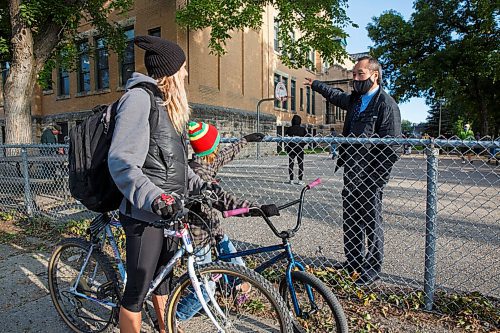 MIKE DEAL / WINNIPEG FREE PRESS
Principal Lionel Pang makes time to talk to Sarah Steinhauer and her son Tyson Jurgens, 11, who have just arrived outside Principal Sparling School Tuesday morning for the first day back to school. 
200908 - Tuesday, September 08, 2020.