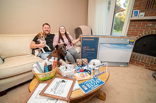 Mike Sudoma / Winnipeg Free Press
Bethany Trapp and her fiancé Tyler Hebel sit behind a few of their wedding social prize packages with their dogs Freya (left) and Barkley (right). The couple is now on their third tentative date for their wedding social as CoVid pandemic restrictions have altered their wedding plans for this year.
September 9, 2020
