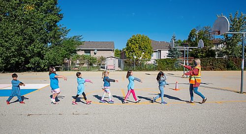 MIKE DEAL / WINNIPEG FREE PRESS
Some of the Blue cohort 1-2 grade kids do the "Monster Walk" while heading inside after recess Friday morning.
Linden Meadows school has assigned cohorts colours and is requiring students to clothing in a specific shade so teachers can tell groups apart and redirect students if they get mixed up on the playground. 
See Maggie story
200911 - Friday, September 11, 2020.