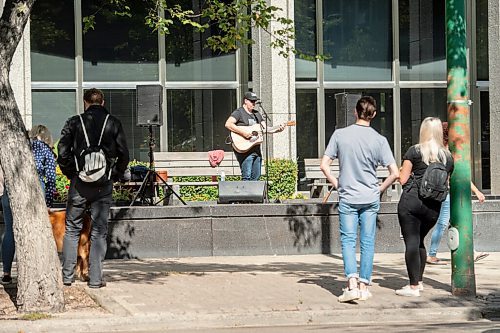 Mike Sudoma / Winnipeg Free Press
A small audience gathers outside the Workers Compensation Board building along Broadway as they listen to local musician Gary Gach as he performs for Minifest Saturday afternoon
September 12, 2020