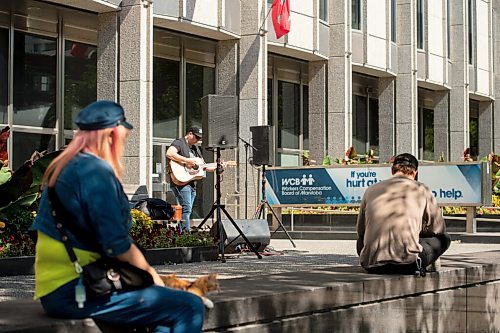 Mike Sudoma / Winnipeg Free Press
A small audience gathers outside the Workers Compensation Board building along Broadway as they listen to local musician Gary Gach as he performs for Minifest Saturday afternoon
September 12, 2020