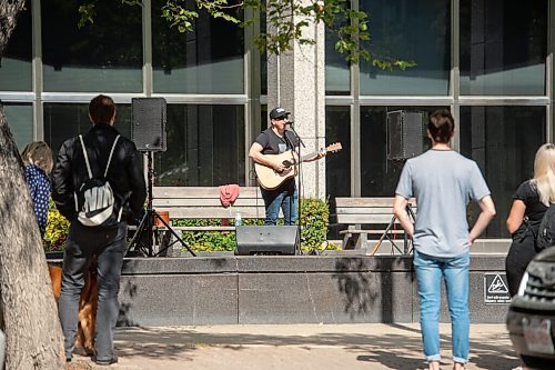 Mike Sudoma / Winnipeg Free Press
A small audience gathers outside the Workers Compensation Board building along Broadway as they listen to local musician Gary Gach as he performs for Minifest Saturday afternoon
September 12, 2020