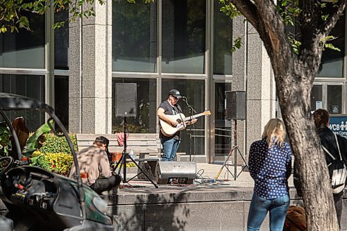 Mike Sudoma / Winnipeg Free Press
A small audience gathers outside the Workers Compensation Board building along Broadway as they listen to local musician Gary Gach as he performs for Minifest Saturday afternoon
September 12, 2020