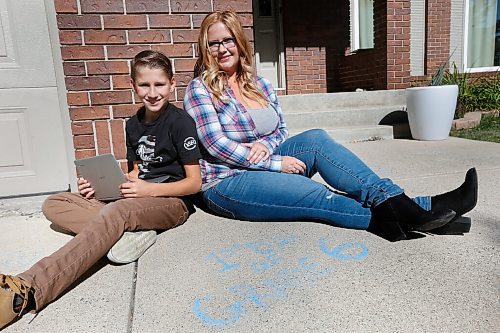 JOHN WOODS / WINNIPEG FREE PRESS
John Pritchard School grade 6 student Connor Gylywoychuk, who does not have COVID-19, and his mother Breanne are photographed beside something he wrote on their driveway on the first day of school outside their home in Winnipeg Thursday, September 17, 2020. Gylywoychuks son was sent home from school as a precaution when a grade 7 student was found to be COVID-19 positive.

Reporter: Abas