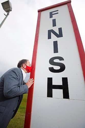 MIKE DEAL / WINNIPEG FREE PRESS
Assiniboia Downs CEO Darren Dunn kissing the finish line sign on the track, signifying the end of a successful season. 
200918 - Friday, September 18, 2020.