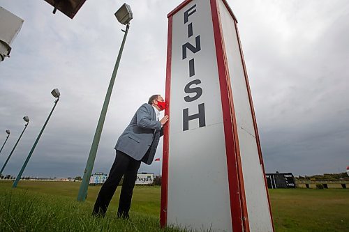 MIKE DEAL / WINNIPEG FREE PRESS
Assiniboia Downs CEO Darren Dunn kissing the finish line sign on the track, signifying the end of a successful season. 
200918 - Friday, September 18, 2020.