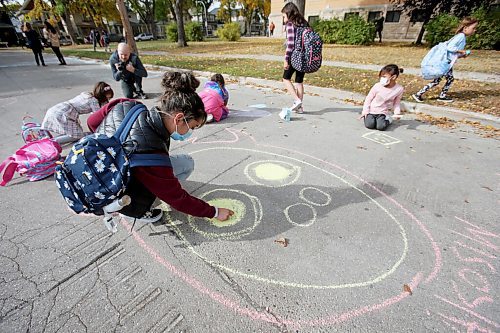 SHANNON VANRAES / WINNIPEG FREE PRESS
Serena Zeid, a Grade 6 student at Isaac Brock School, enjoys the space created by the School Street Project, a pilot program and collaborative effort by the The Green Action Centre and the City of Winnipeg, by drawing with chalk. The first of its kind in Manitoba, the project involves closing the street in front of schools to vehicles for a few hours each day, giving students more space to walk, bike and play while maintaining physical distance.