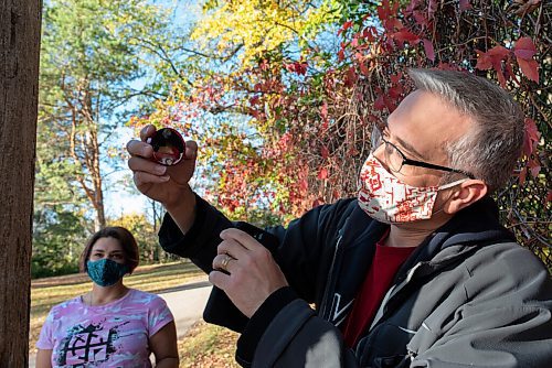 JESSE BOILY  / WINNIPEG FREE PRESS
Jordan McPeek shows another geocache find in Assiniboine Park on Tuesday. Geocaching is like a treasure hunt around the city using GPS locations that hide lists of people who found the cache. Tuesday, Sept. 29, 2020.
Reporter: Brenda Suderman