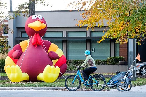 Daniel Crump / Winnipeg Free Press. A cyclist rides past a giant inflatable turkey on the front lawn of a Wellington Crescent home. The Manitoba government has provided updated guidelines and recommendations on how to celebrate fall holidays in a way meant to keep people safe during the coronavirus pandemic. October 3, 2020.