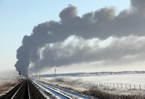Brandon Sun 06112009 Billowing smoke is seen from the CN line passing through Spy Hill, SK, after a CN train derailment east of Spy Hill on Saturday, December 6, 2009. A freight train derailed at approximately 7:00 AM causing a large fire that forced the evacuation of nearby homes. Because of the components of the train cars and the ferocity of the fire, rescue crews could do nothing but secure the scene and watch the fire from a distance. No one is believed to have been injured in the derailment and subsequent fire. The town and R.M. of Spy Hill has declared a pre-emptive state of emergency in case shifting winds force the evacuation of the town.  (Tim Smith/Brandon Sun)