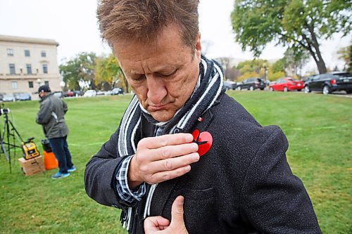 MIKE DEAL / WINNIPEG FREE PRESS
Manitoba minister of infrastructure, Ron Schuler puts on a sticker before speaking at the Justice for PS 752 rally at the Manitoba Legislative building Monday morning which was part of a worldwide rally happening at the same time. 
201005 - Monday, October 05, 2020.