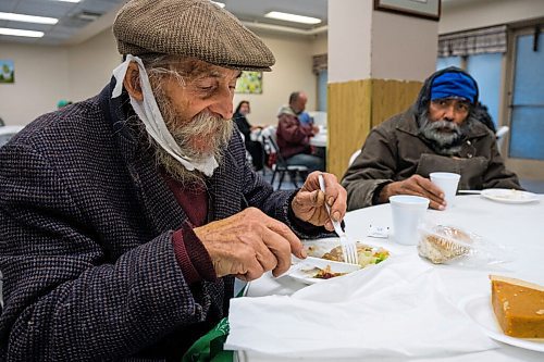 Daniel Crump / Winnipeg Free Press. Joseph Kipka (left) eats a tradition turkey meal with is neighbour Simon Bede (right) during Union Gospel Missions annual thanksgiving meal. October 10, 2020.