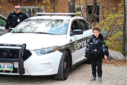 Canstar Community News A youngster is allowed to try on a police vest by a friendly officer at Henteleff Park, off St. Mary's road near the Perimeter Highway.