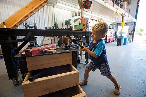 MIKE DEAL / WINNIPEG FREE PRESS
Colin Penner's son Everett hammers away at his own work bench that his grandfather made for the grandkids.
See Eva Wasney story
200904 - Friday, September 04, 2020.