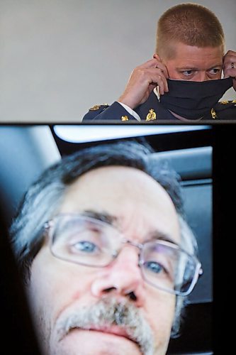 MIKE DEAL / WINNIPEG FREE PRESS
Supt. Michael Koppang, Officer in Charge of RCMP Major Crime Services puts on his mask behind a television monitor with Bud Paul's photo on display. The press conference, at RCMP D Division Headquarters Wednesday morning, was to announce that the remains that were located in Roseau River Anishinabe First Nation are those of Bud Paul, who had been the subject of a missing person investigation since August 7, 2020. Bud Paul was a 56-year-old male from Winnipeg reported missing to the Winnipeg Police Service on August 7, 2020.
201014 - Wednesday, October 14, 2020.