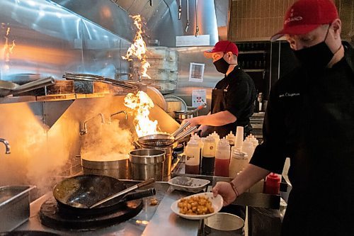 JESSE BOILY  / WINNIPEG FREE PRESS
Jason Chapman, executive chef, and sous chef Dustin Bernacki cook with some big flames at P.F. Chang's on Friday. Friday, Oct. 16, 2020.
Reporter: