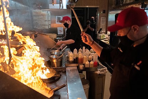JESSE BOILY  / WINNIPEG FREE PRESS
Jason Chapman, executive chef, and sous chef Dustin Bernacki cook with some big flames at P.F. Chang's on Friday. Friday, Oct. 16, 2020.
Reporter: