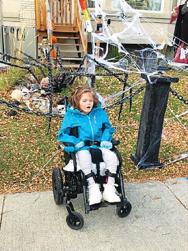 Canstar Community News Willow Siedler poses with Willow's Web, a Halloween display outside her family's home that symbolizes the web of people and organizations working to cure the rare genetic disorder she lives with.