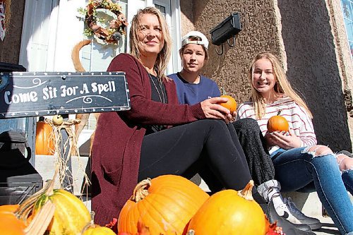 Canstar Community News Charlene Henry sits on her neighbour's porch with her children, Adam and Amber, on Oct. 13. The trio is surrounded by pumpkins they picked. They're on their neighbour's porch because they don't have pumpkins on their own -- they gave them all away. (GABRIELLE PICHÉ/CANSTAR COMMUNITY NEWS/HEADLINER)