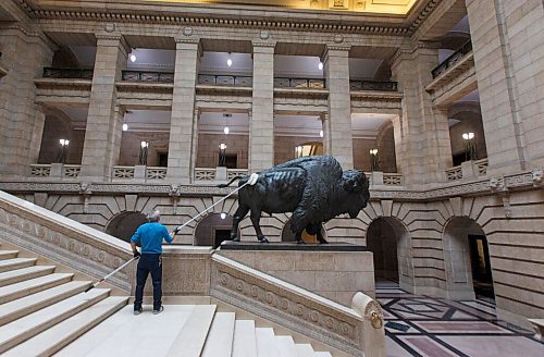 MIKE DEAL / WINNIPEG FREE PRESS
August Gilo with building maintenance at the Manitoba Legislative building cleans one of the two bison that line the grand staircase Wednesday afternoon.
201028 - Wednesday, October 28, 2020.