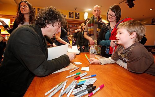 BORIS.MINKEVICH@FREEPRESS.MB.CA BORIS MINKEVICH/ WINNIPEG FREE PRESS  091215 Best selling author Neil Gaiman signs books at McNally Robinson Polo Park. Young fan Kieran Thiessen,7, gets an autograph. His mother Jennifer Iverach-Brereton and Boern Thiessen (behind mum from right) in photo.