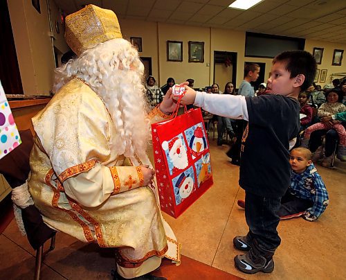 BORIS.MINKEVICH@FREEPRESS.MB.CA BORIS MINKEVICH/ WINNIPEG FREE PRESS  091215 The Welcome Home inner city mission had an event at St. Andrews Church(160 Euclid) for kids in the area. Four year old Derek Courchene cives a gift back to St. Nick after getting one from him.