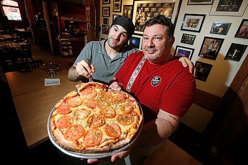 JOHN WOODS / WINNIPEG FREE PRESS
Alfonso Maury, owner of Corrientes pizzeria and La Pampa empanada shop, and his son Ivo show off a Las Cuartetas pizza at his pizzeria Thursday, October 29, 2020. 

Reporter: Sanders