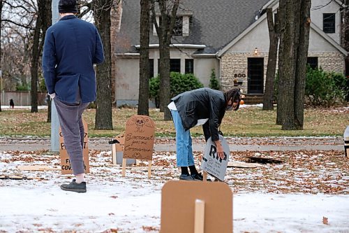 Daniel Crump / Winnipeg Free Press. Passersby re-erect cardboard tombstones that have been setup on wellington crescent outside Manitoba Premier Brian Pallisters home on Wellington Crescent. October 31, 2020.