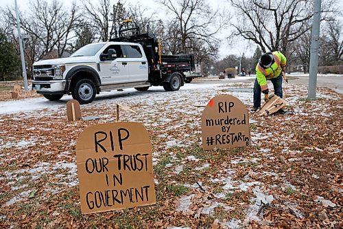 Daniel Crump / Winnipeg Free Press. City crews remove cardboard tombstones and an effigy of Manitoba Premier Brian Pallister dressed as the grim reaper that was set up in front of the Premiers wellington crescent home. The mock graveyard is a protest over the provincial governments handling of the coronavirus pandemic. October 31, 2020.