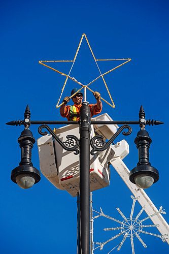 MIKE DEAL / WINNIPEG FREE PRESS
Dustin Kipling with MyTec Industries Ltd. puts up Christmas lights along Portage Avenue, Tuesday afternoon.
201103 - Tuesday, November 03, 2020.