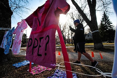 Daniel Crump / Winnipeg Free Press. A person takes pictures on his phone of a protest art instalment on the boulevard at wellington crescent set up by concerned health care workers. November 7, 2020.