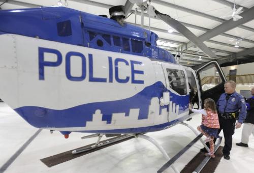 Former Colorado Springs Police Dept. helicopter pilot Chris Burns helps his daughter, Megan Burns, climb one of the two helicopters of the CSPD. The helicopters are being sold and the program is being shut down. Tuesday, December 22, 2009.  (The Gazette/Jerilee Bennett) for winnipeg free press