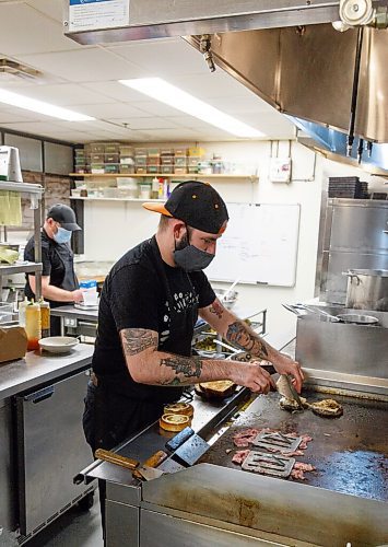 MIKE DEAL / WINNIPEG FREE PRESS
Clementine restaurant at 123 Princess Street has reconfigured some of their eating space to prep space for takeout now that they can not have sit-down customers.
Paul Eccles, chef de cuisine, puts an order of burgers together for an online customer. 
See Malak Abas story.
201113 - Friday, November 13, 2020.