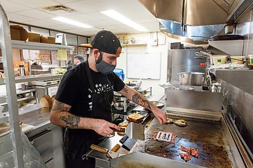 MIKE DEAL / WINNIPEG FREE PRESS
Clementine restaurant at 123 Princess Street has reconfigured some of their eating space to prep space for takeout now that they can not have sit-down customers.
Paul Eccles, chef de cuisine, puts an order of burgers together for an online customer. 
See Malak Abas story.
201113 - Friday, November 13, 2020.