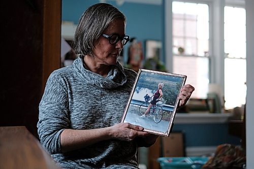 Daniel Crump / Winnipeg Free Press. Lilian Bonin looks at a photo of her mother, Christine Bonin, on a cycling trip to Vermont that the two took together 30 years ago. Christine Bonin died, age 89, of complications from COVID-19 after contracting the virus at Victoria Hospital. November 21, 2020.