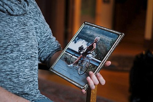 Daniel Crump / Winnipeg Free Press. Lilian Bonin holds a photo of her mother, Christine Bonin, who died from complications of COVID-19 at Victoria Hospital in Winnipeg.   The photo shows Lilians mother with her bicycle during a cycling trip to Vermont that the two took together 30 years ago. November 21, 2020.