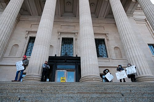 Daniel Crump / Winnipeg Free Press. A few people with signs stand on the stairs of the Manitoba Legislature to protest pandemic safety measures put in place by the government. November 21, 2020.