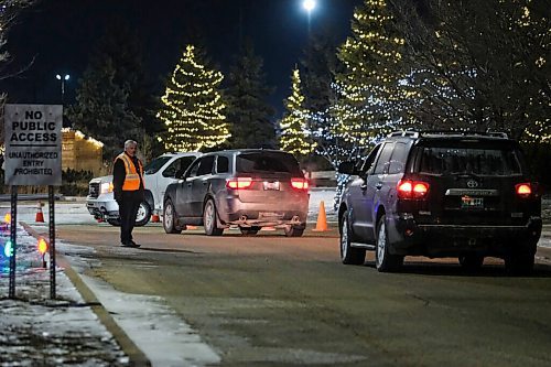 Daniel Crump / Winnipeg Free Press. Church Springs private security stands guard as vehicles line-up to attend a drive-in church service. November 28, 2020.