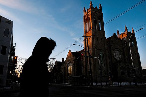 Daniel Crump / Winnipeg Free Press. A person walks north on Maryland Street as the last rays of the setting sun cause the bell tower of Westminster United Church to glow a deep orange. November 30, 2020.