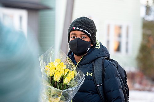 Mike Sudoma / Winnipeg Free Press
Gebreal, a student enrolled in the West Broadway Youth Outreach after school program, holds up his flowers as he awaits his limousine ride home as a result of achieving  improved marks on his latest report card Thursday evening
December 3, 2020
