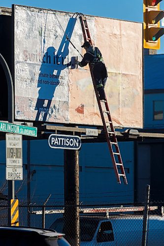 MIKE DEAL / WINNIPEG FREE PRESS
Chuck Reid, with Robson Maintenance Service, installs a new billboard at Arlington Street and Logan Avenue Friday morning.
201204 - Friday, December 04, 2020.