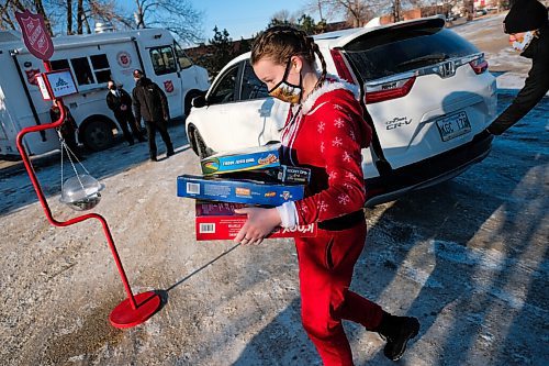 Daniel Crump / Winnipeg Free Press. Anna Cameron, a volunteer for the Salvation, carries donated toys to be sorted. The donations are part of the Salvation Armys Toy Mountain donation drive which is being done as a drive-in this year. December 5, 2020.