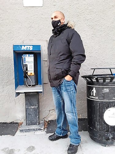 Canstar Community News Longtime neighbourhood resident Joshua Wheelright (who carries a cell phone) strolls by the payphone at Jamison Food Mart.