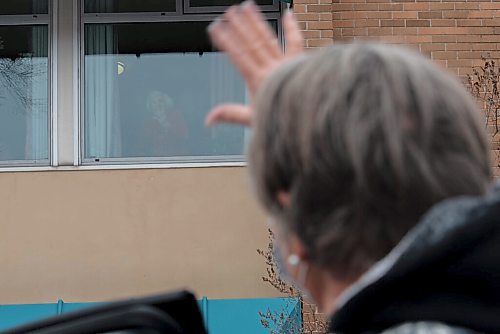 JESSE BOILY  / WINNIPEG FREE PRESS
Jackie Greig waves to her mother Mary Corbett, 103, who had contracted COVID-19 and recovered at Park Manor Personal Care Home on Tuesday. Greig said that she has gone by to wave to her mother almost daily since March. Corbett shares a room with four other residents all who had contracted COVID-19 according to Greig.  Tuesday, Dec. 8, 2020.
Reporter: