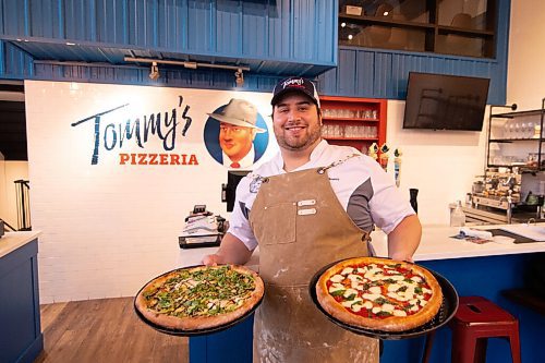 Mike Sudoma / Winnipeg Free Press
Tommys Pizzeria owner, Thomas Schenider, holds up two freshly made signature pizzas, the Audrey Mayer (left) and the Nick Bean Wednesday evening
December 9, 2020