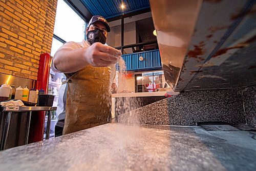 Mike Sudoma / Winnipeg Free Press
Tommys Pizzeria owner, Thomas Schenider, flour along his kitchens countertop as he prepares the space for a Wednesday evening full of orders.
December 9, 2020