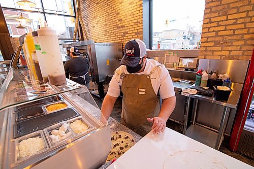 Mike Sudoma / Winnipeg Free Press
Tommys Pizzeria owner, Thomas Schenider,puts toppings on one of his signature pies Wednesday evening.
December 9, 2020